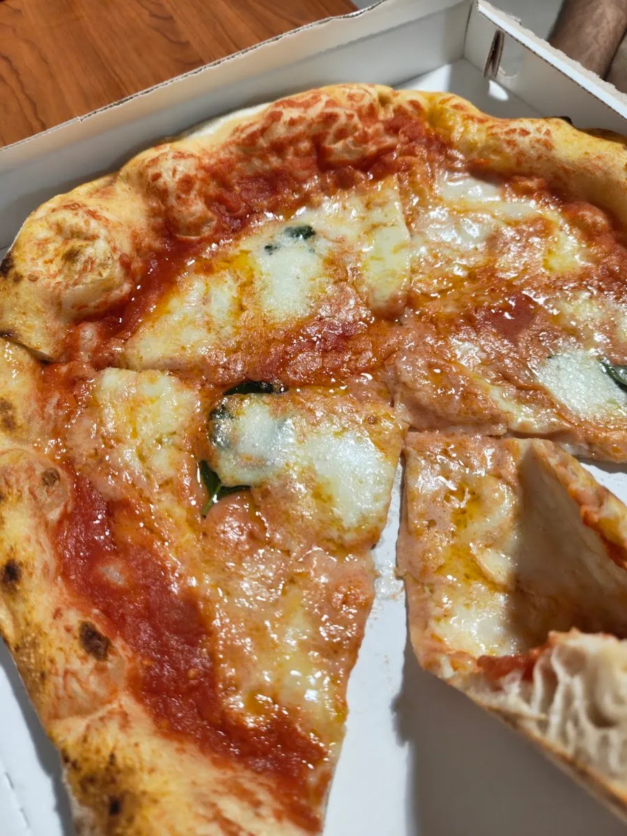 Pizza da asporto tagliata a spicchi nel cartone